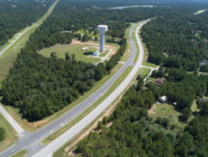 Aerial image of cars driving past water tower on thoroughfare